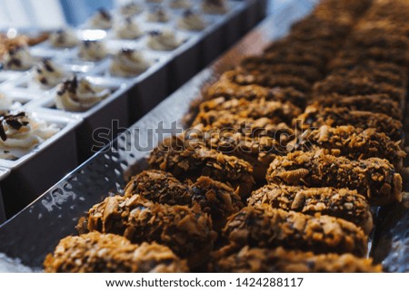 Sweet desserts and pastries on the table during the event. Catering servicing of guests and participants during mass events. Large number of sweet and cupcakes. Soft focus, bokeh, abstract.
