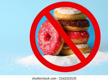 Sweet donuts and prohibition sign on light blue background. No sugar - Shutterstock ID 2162323135