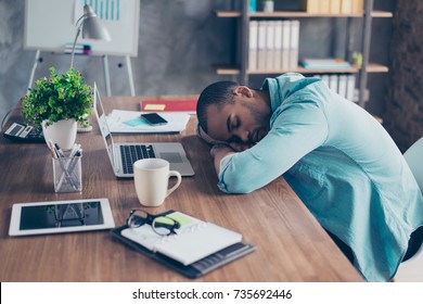 Sweet dreams in the work station. Sleepy tired freelancer is snoozing at his work place, coffee cup and office stuff near on desk top - Powered by Shutterstock