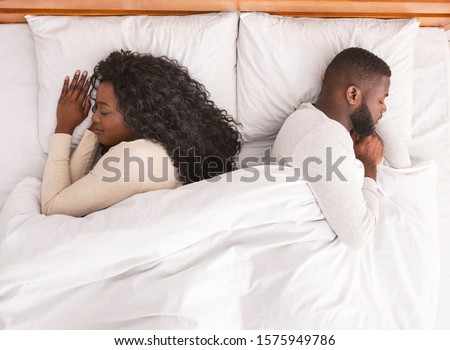 Sweet dreams. Young african american couple napping back to back in confortable bed at home, top view with free space
