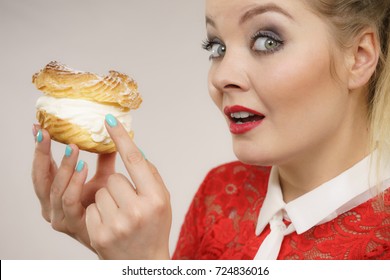 Sweet Food And Happiness Concept. Funny Joyful Blonde Woman Holding Yummy Choux Puff Cake With Whipped Cream, Excited Face Expression. On Grey