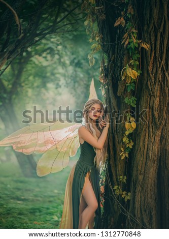 sweet forest angel, nymph with perfect thick white hair in image of dreamy spirit with butterfly wings. attractive fairy with bare legs, mythical creature closes eyes, listens to breath of nature.