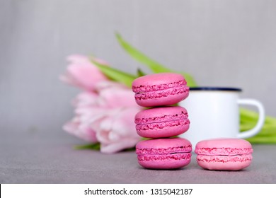 Sweet french macarons, cup of tea/coffee and spring flowers on grey background - Powered by Shutterstock