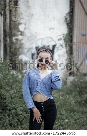 
Sweet girl wearing sunglasses using a slightly open jeans jacket