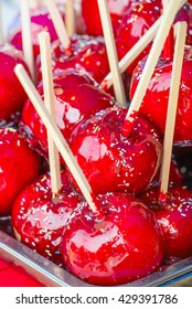 Sweet Glazed Red Toffee Candy Apples On Sticks For Sale On Farmer Market Or Country Fair.