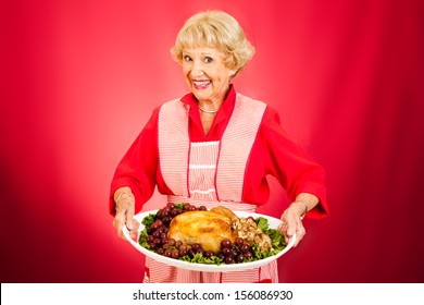 Sweet grandmother holding a beautifully cooked turkey dinner.   - Powered by Shutterstock