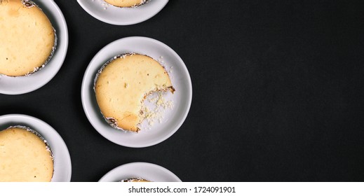 Sweet Handmade Cookies On A Black Background. One Cookie Bitten Off. White Plates With Confectionery. Top View, Copy Space