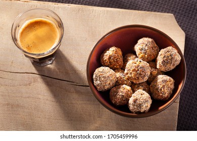 Sweet handmade fruit balls covered with oats and a cup espresso seen from above