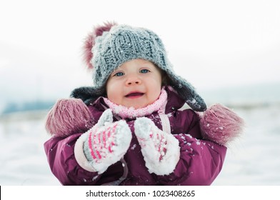 sweet happy baby, winter outdoor playing with snowflakes fun lovely girl portrait with blue eyes and smile, enjoy weather, love family, beautiful childhood - Shutterstock ID 1023408265