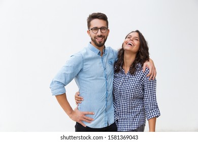 Sweet happy couple hugging each other and laughing. Young woman in casual and man in glasses in glasses posing isolated over white background. Love and friendship concept - Shutterstock ID 1581369043