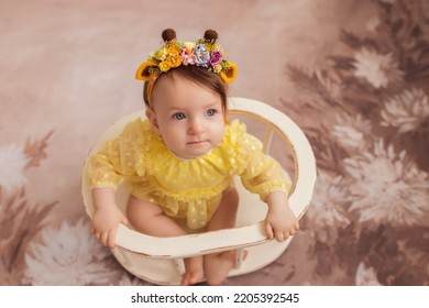 Sweet Happy Girl. Ten Months. Baby On A Flower Background.Children's Photoshoot.Photoshoot At Ten Months.