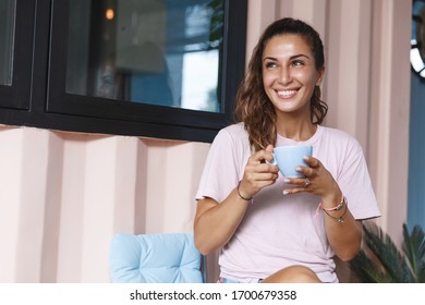 Sweet Home, Leisure And Happy Moment Concept. Smiling Woman Drinking Coffee, Hold Tea Cup And Look Away, Enjoying View Outdoors On Nature While Self-quarantine, Sit House Porch During Lockdown