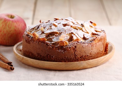 sweet homemade apple cake with almond in wooden plate