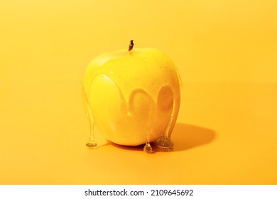 Sweet Honey Flowing Down From Ripe Apple On Color Background