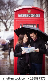 Sweet honeymoon couple consulting map in London