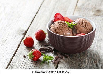 Sweet ice cream in bowl on grey wooden background