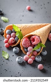 Sweet ice cream with frozen berries in cone. Frozen fruit in a cone as a sorbet.