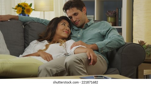 Sweet Interracial Couple Relaxing On Couch Together