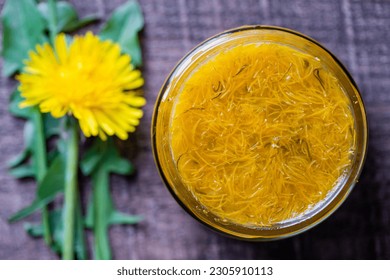Sweet jam in glass jar jam from ripe yellow petals of dandelion flowers, orange, lemon and sugar, top view, close up. Dandelion famous medicinal plant - Shutterstock ID 2305910113