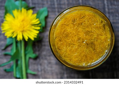 Sweet jam in glass jar jam from ripe yellow petals of dandelion flowers, orange, lemon and sugar, top view, close up. Dandelion famous medicinal plant - Shutterstock ID 2314332491