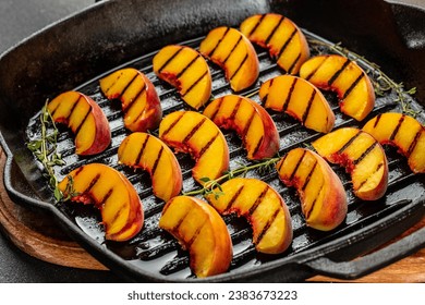 Sweet and juicy roasted peaches on a a grill pan on a dark background. top view. - Powered by Shutterstock