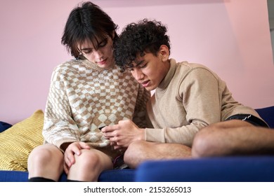 Sweet Latino Gay Couple Cuddling In The Couch With Electronics