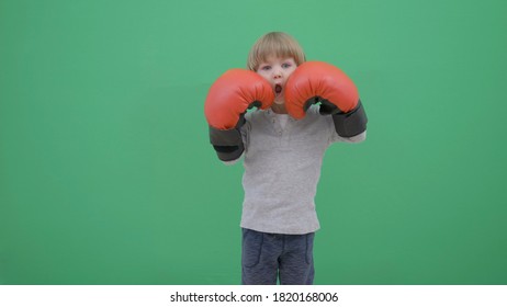 Sweet little boy playing boxing with big red gloves - Powered by Shutterstock