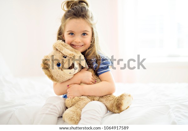 girl hugging stuffed animal