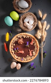 Sweet Mazurka chocolate cake surrounded by eggs and catkins. Cake, catkins and Easter eggs for Easter.