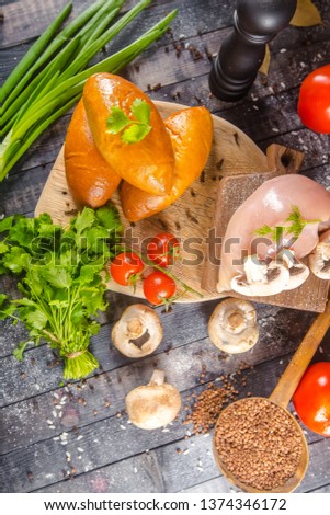 sweet meat pies, bun, bread, dough on a wooden vintage cutting board old rustic, chili, with tomatoes, greens dill, on the table top, side, bottom shot angle, fork and knife mushrooms mushrooms