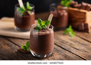 Sweet mousse with chocolate and mint on the rustic table, selective focus