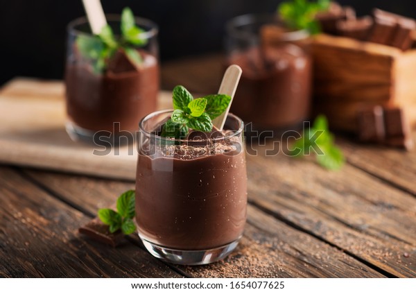 Sweet mousse with chocolate and mint on the rustic\
table, selective focus