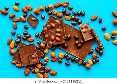 Sweet pattern. Different variety of chocolate and hazelnut on blue background top view