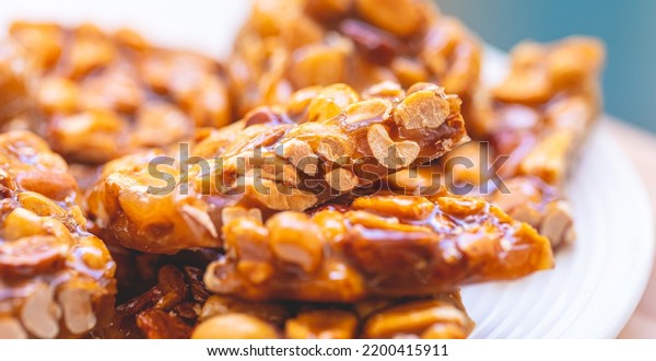 Sweet\
peanut brittle on a white plate. Macro\
photography.