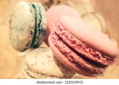 sweet pink macaroon with black grains in a metal cup is on the table, blurred background, pastel toning