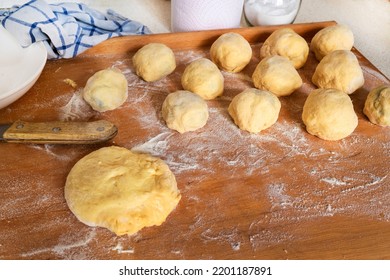 Sweet plum dumpling and piece of yeast dough. Preparation of plum dumpling on wooden kitchen board.  - Powered by Shutterstock