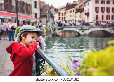 Sweet portrait of preschool boy in the town of Annecy, France, springtime, enjoying the view of the channel