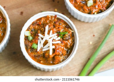 Sweet Potato And Black Bean Chili In A Ramekin. Vegan Cheese And Scallions On Top.