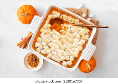 Sweet potato casserole with toasted marshmallows. Overhead view table scene on a white marble background. Thanksgiving food concept. - Powered by Shutterstock