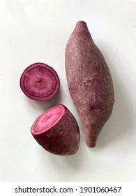 Sweet potato close-up isolated on white background. Raw purple Sweet-potato closeup with slide cut