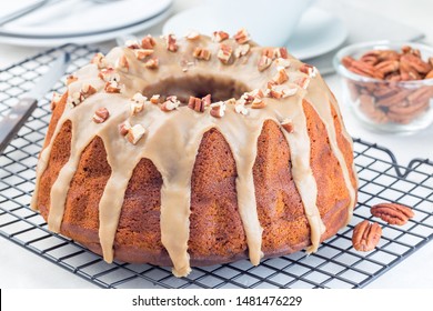 Sweet potato and pecan nuts pound cake with caramel icing on a  cooling rack, horizontal