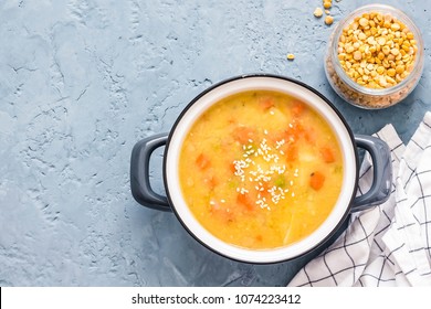 Sweet potato split pea soup in a pot on blue concrete background. Top view, copy space.