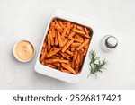 Sweet potato wedges in white baking dish, top view