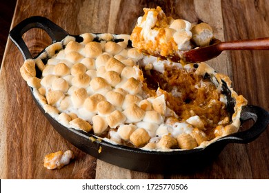 Sweet potatoes or candied yams. Classic American thanksgiving side dish. Served with toasted marshmallows, cheese, garnished with scallions and Italian parsley and served in cast iron skillet. 
