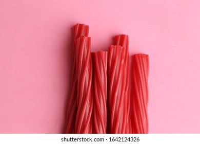 sweet red gummy licorice on color background