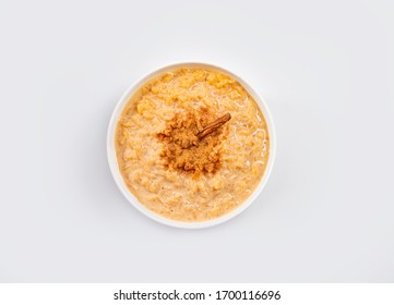 sweet rice with cinnamon in white bowl isolated on white background, traditional Brazilian food, top view. - Shutterstock ID 1700116696