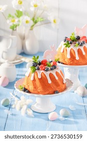 Sweet ring cake for Easter as perfect Easter card. Easter spring background with flowers and easter eggs.