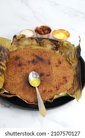 Sweet roti made out of rice flour, jaggery, and ghee. Gud ki roti. 
gur ki roti, jaggery Bhakri, meethi gud ki roti cooked in banana leaf. Winter food. Copy space.