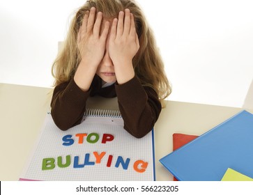 sweet sad and depressed young schoolgirl with stop bullying text on notebook  looking helpless and scared as victim of bullying at school in education problem concept isolated white background - Powered by Shutterstock