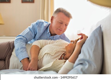 Sweet Senior Couple Cuddling In Bed